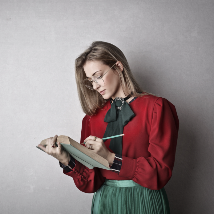 kobieta w czerwonej marynarce trzyma książkę