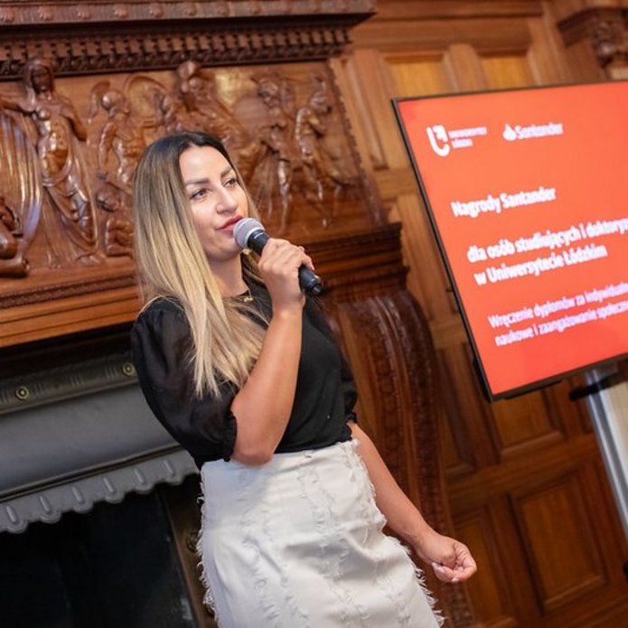 przedstawicielka firmy trzymająca mikrofon