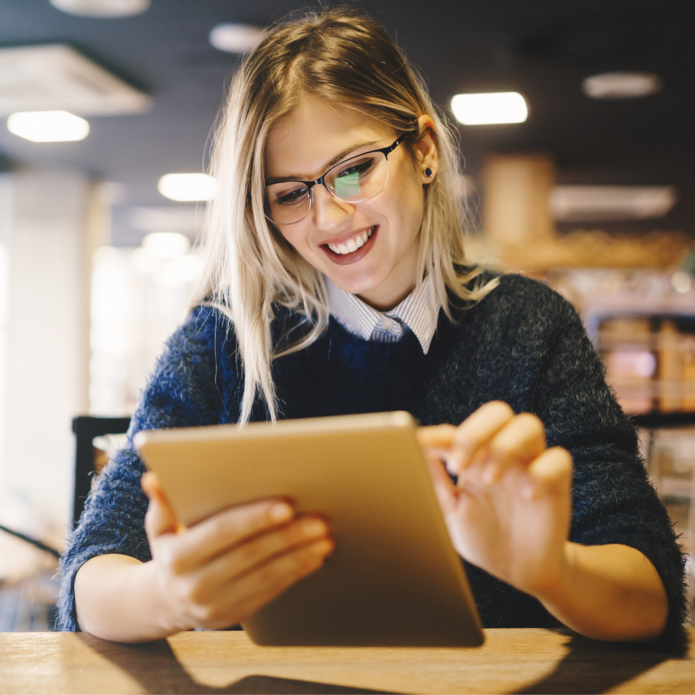 kobieta w okularach pracująca na tablecie